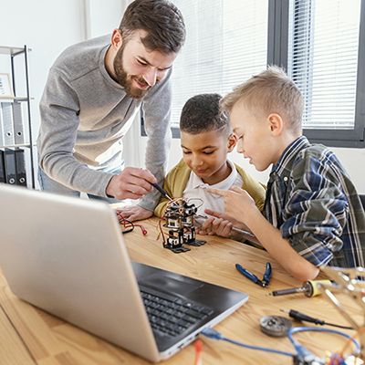 adult making a little robot with two children