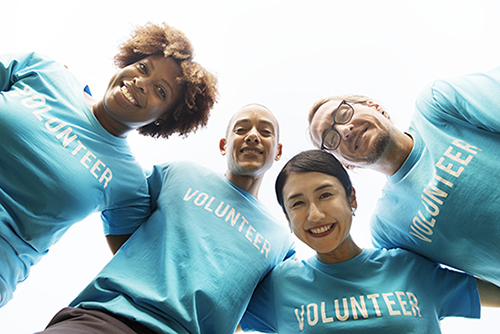 volunteers in blue shirts smiling to the camera