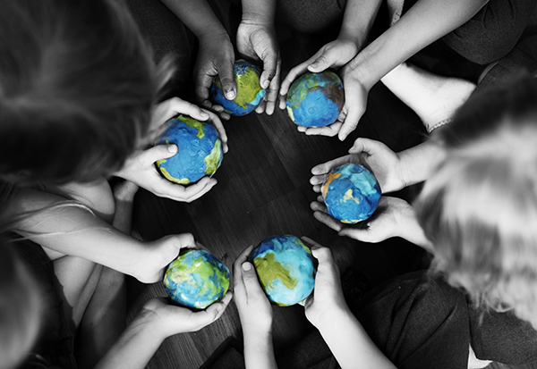 children holding handmade earth in hands standing in a circle